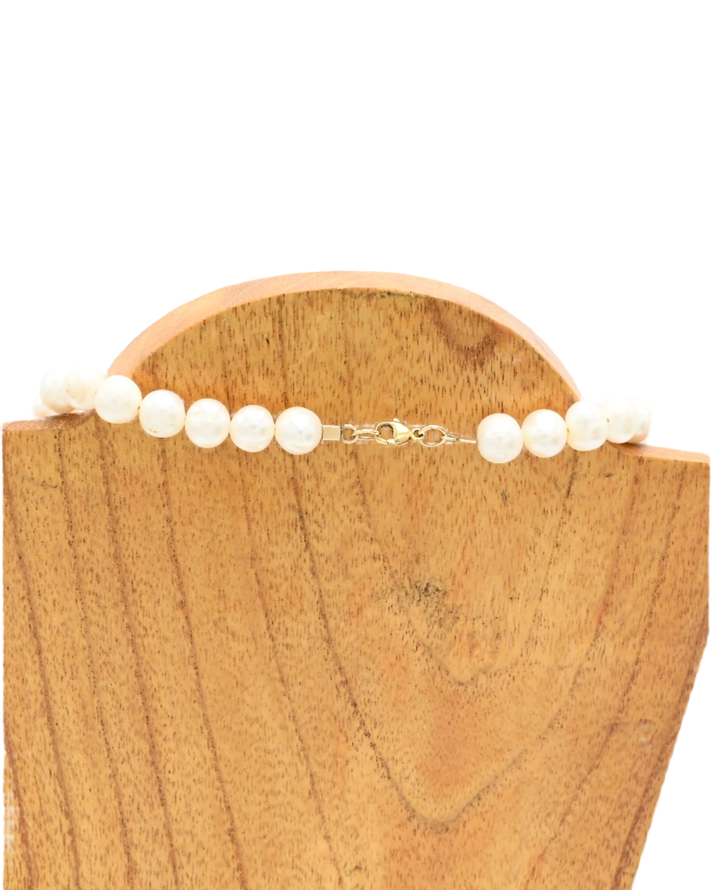 Pearl necklace on a wooden block with a white background