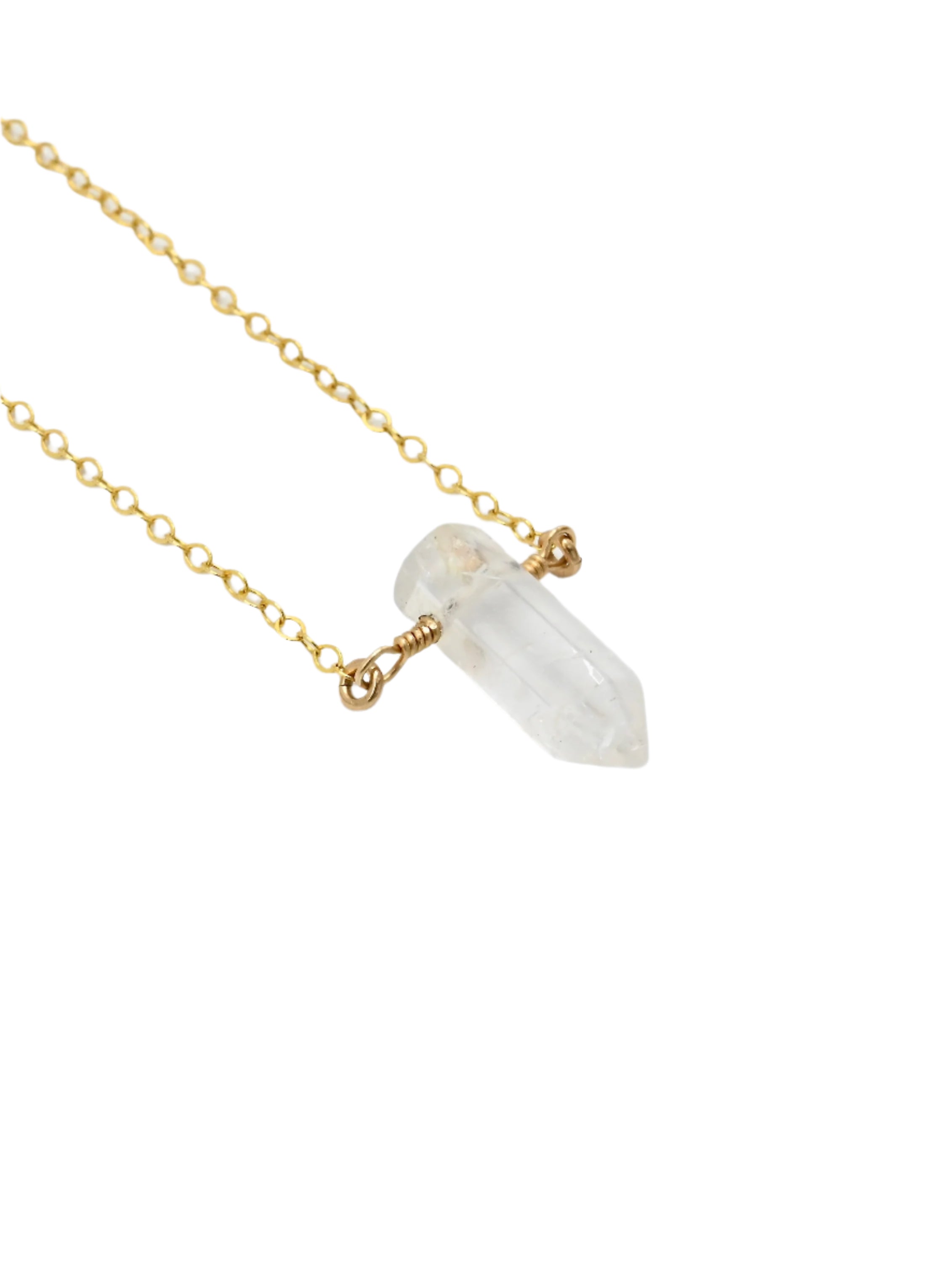 Necklace with a clear quartz crystal point pendant on a white background