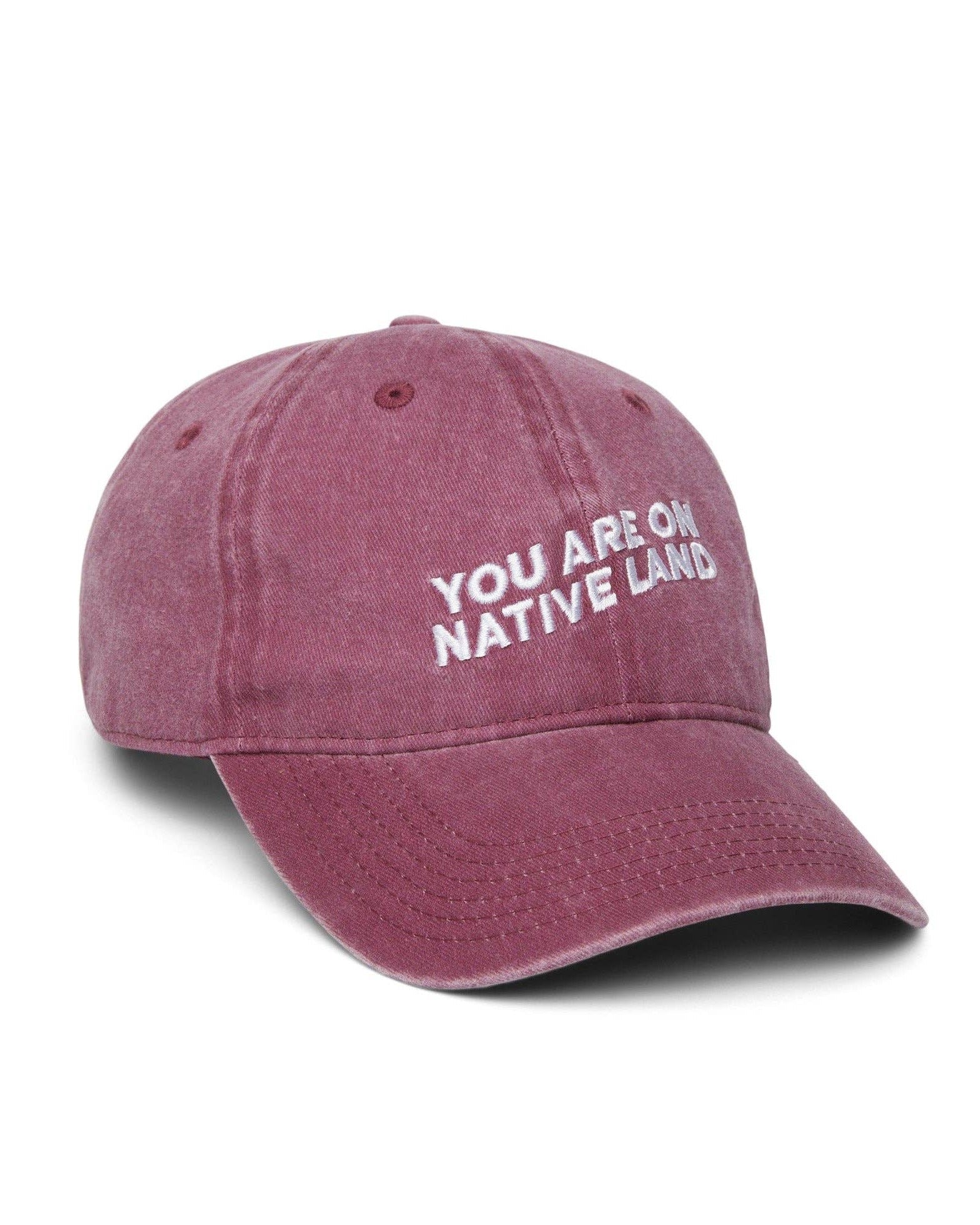 Maroon cap with 'YOU ARE ON NATIVE LAND' text on a white background