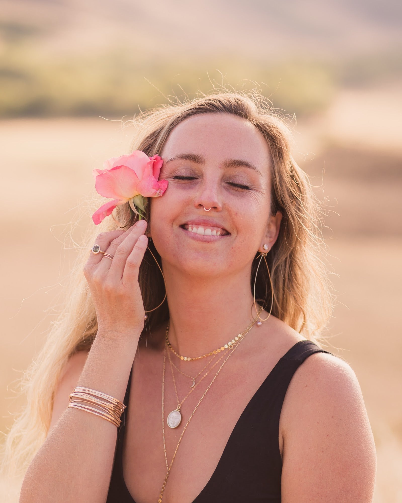 Woman with a pink flower in her hair standing in a field