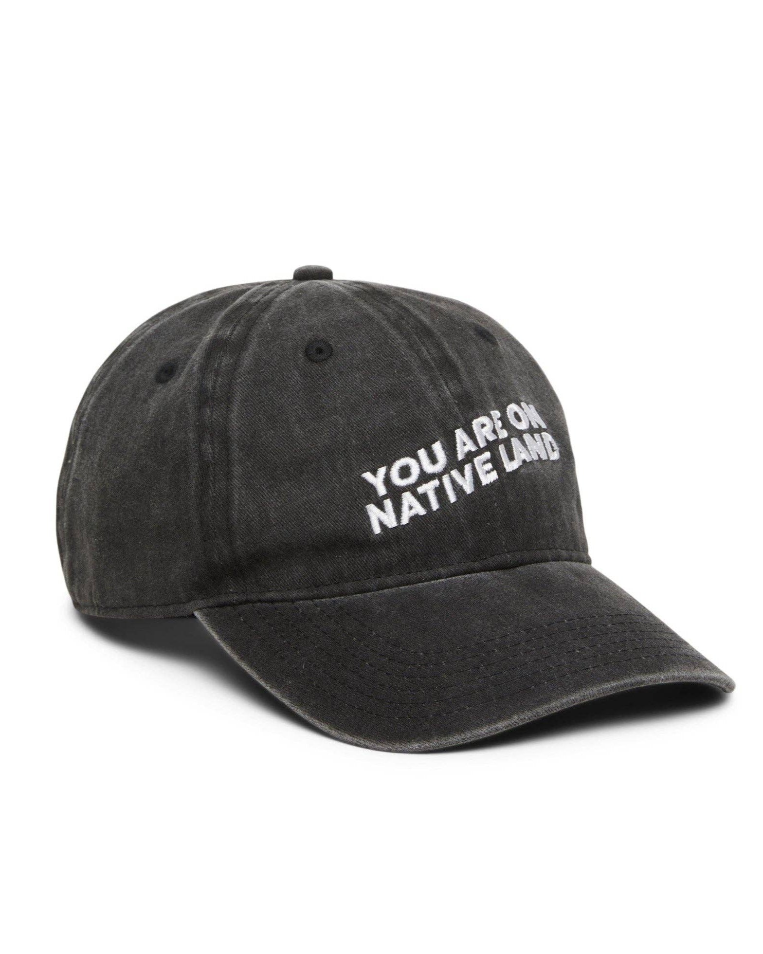 Black cap with 'YOU ARE ON NATIVE LANDS' text on a white background