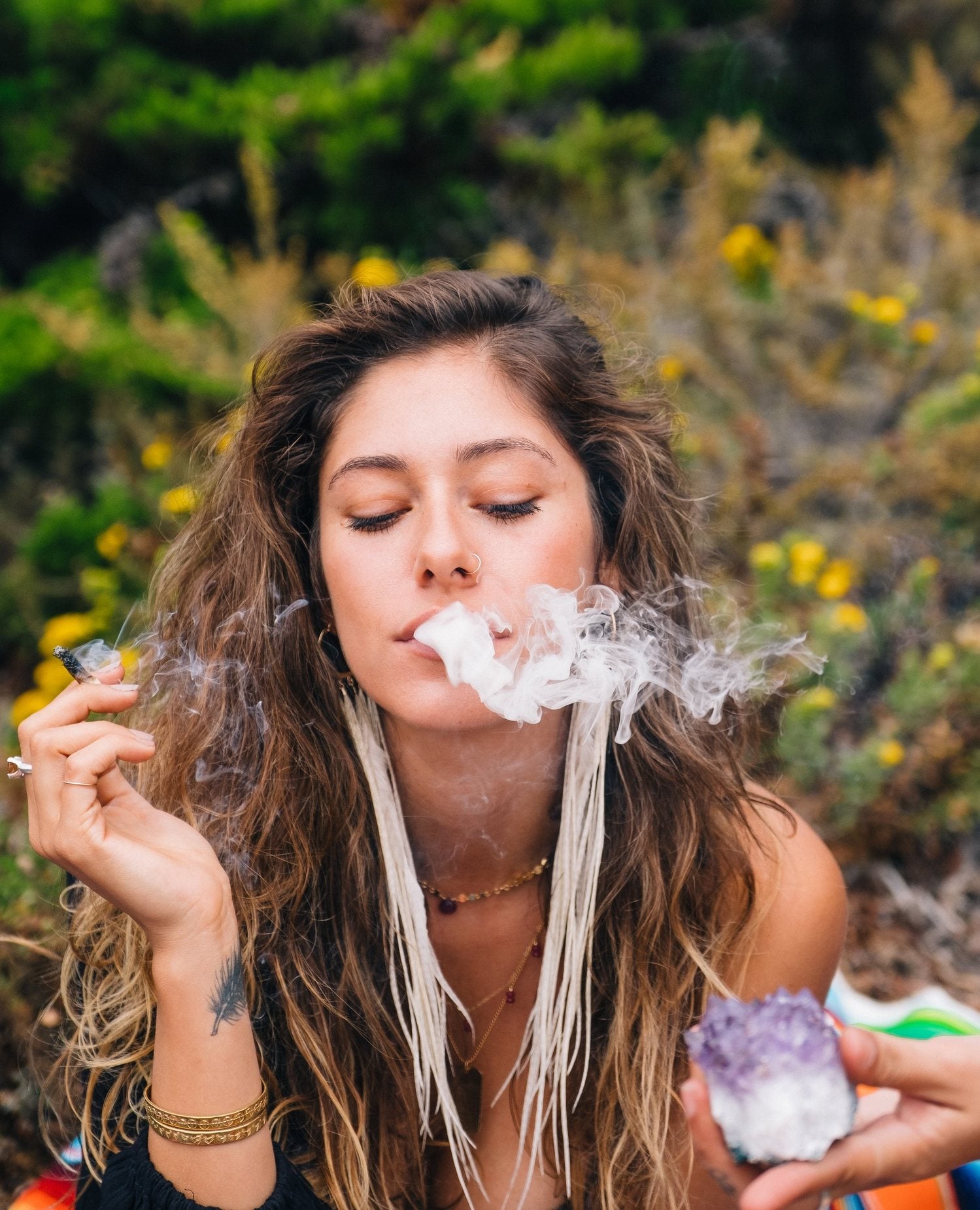 Woman smoking with smoke visible outdoors