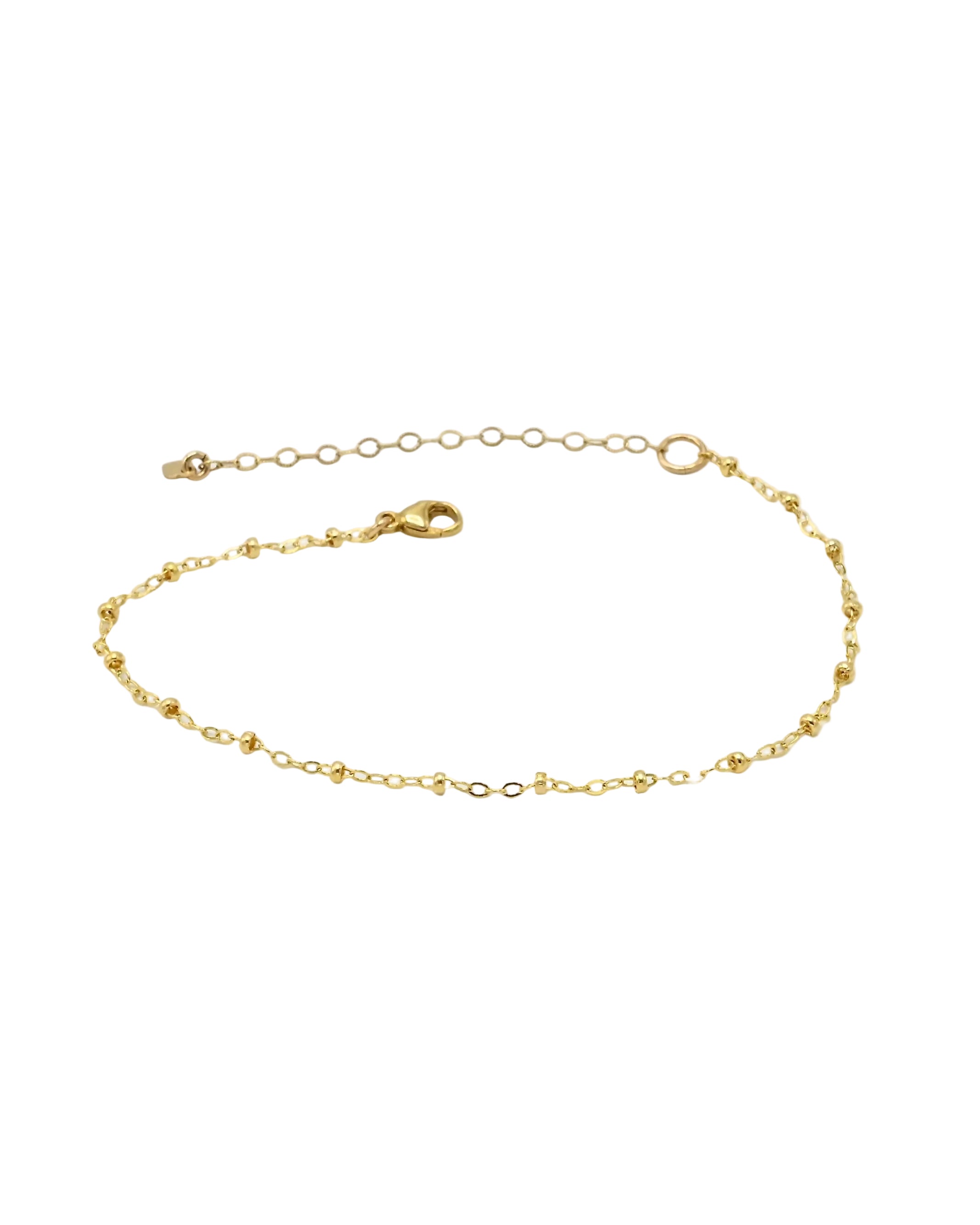 A delicate gold chain bracelet with small bead-like links, a lobster clasp, and an adjustable extension chain, displayed on a clean white background.
