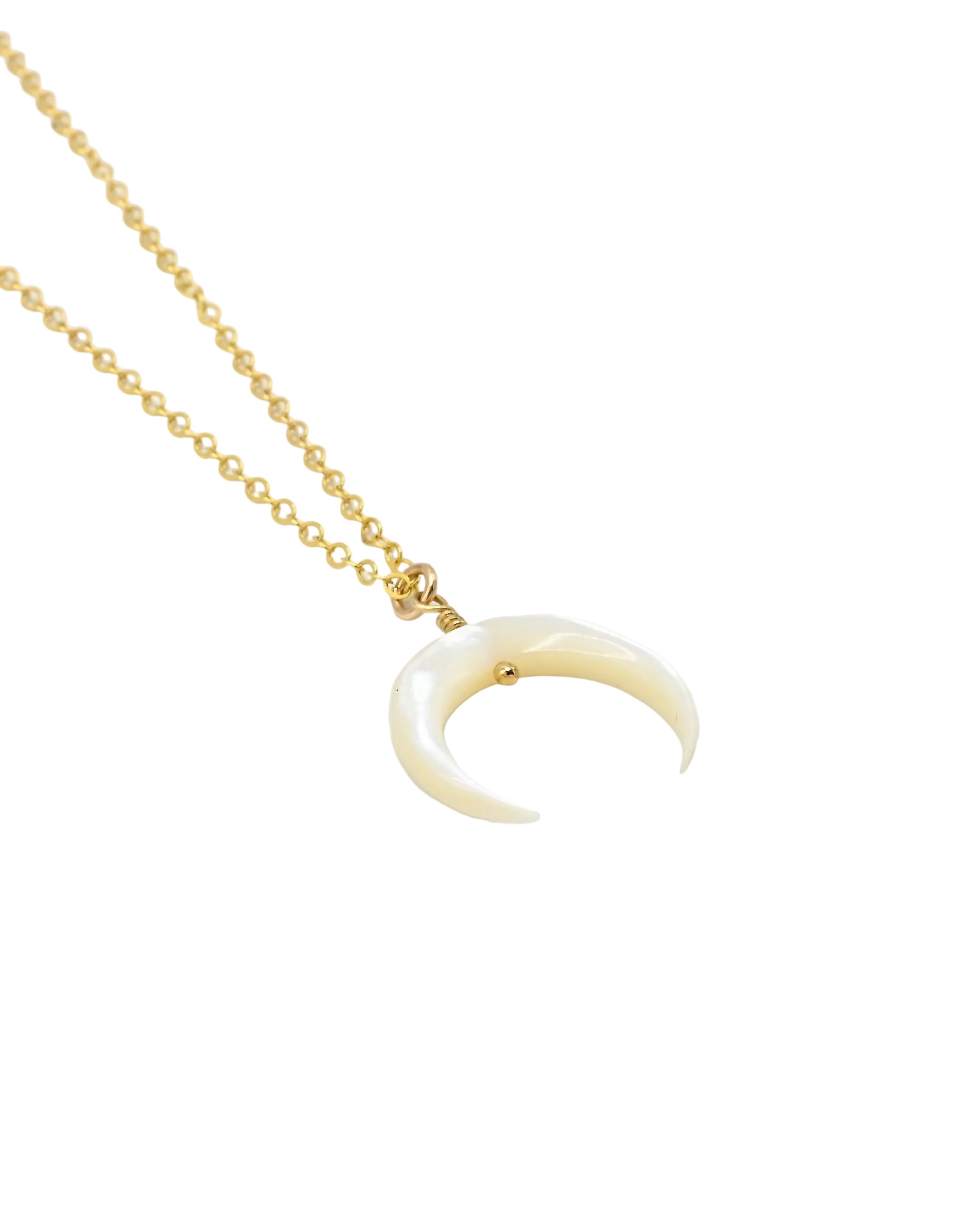 A gold chain necklace featuring a crescent moon pendant made of cream-colored bone or horn, displayed on a clean white background.